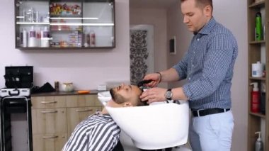 Geniş çerçeve, müşterilerin saçını yıkayan bir değirmen makinesiyle ya da saç kesimi işleminden sonra.