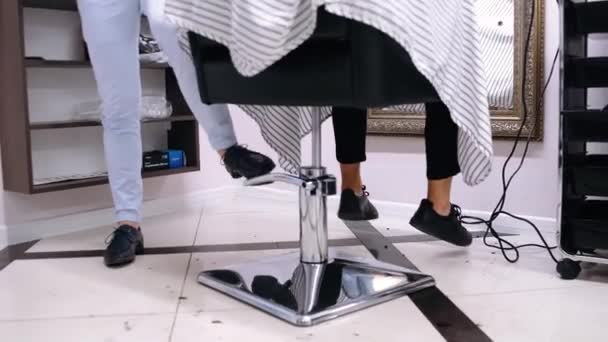 Grave pouco masculino adolescente cliente sentado no barbeiro cadeira no interior hipster barbearia. — Vídeo de Stock