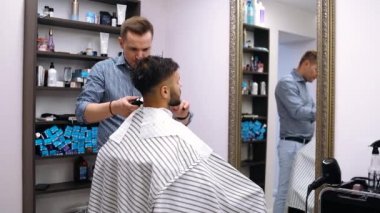 Usta saç kesiminin hatlarını belirler. Berber dükkanında erkek tıraşı.