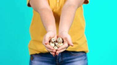 Genç kadın elinde bir sürü bıldırcın yumurtası tutuyor..