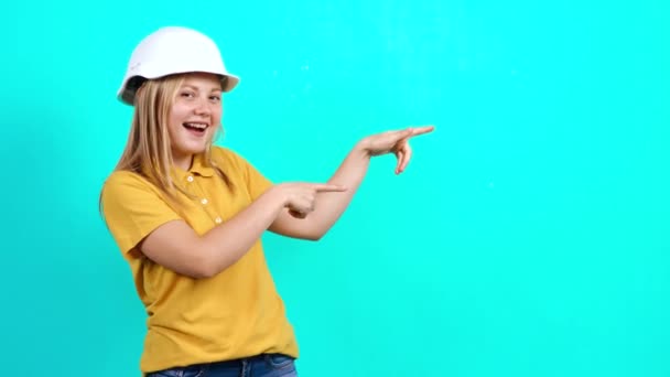 La joven ingeniera señala con las manos en el lado izquierdo del fondo, recomendando un producto — Vídeos de Stock