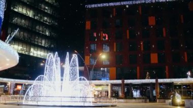 Modern bina bir sürü ışık, şenlikli atmosfer, dışarıda kar, kar taneleri ile süslenmiş..