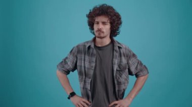 Hipster elleri ortada, öfkeyle kameraya bakıyor.