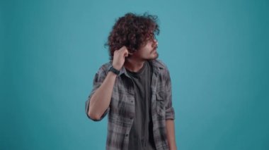 Elini kulağına dayamış genç hippi meslektaşın, ofis arkadaşının duyduklarını duymuyor.