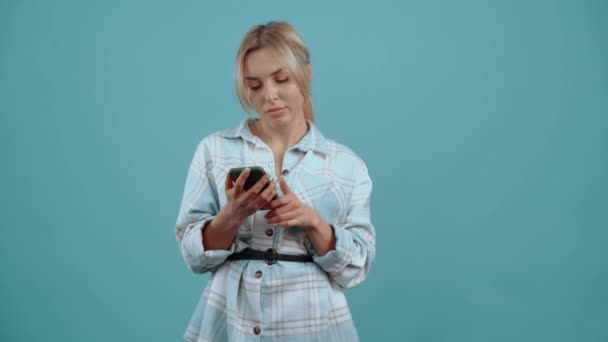 Incroyable jeune femme, elle surfe sur le téléphone puis regarde à droite dans l'étonnement, et à la fin, elle ressemble à regarder la caméra — Video