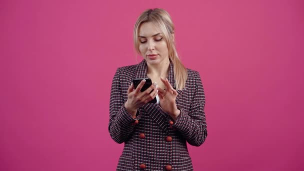 De attente jonge vrouw kijkt aan de telefoon, ziet iets interessants en grappigs naar rechts wijzen, glimlacht en verheugt zich. — Stockvideo