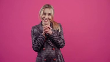 Genç kadın, birinin zaferi karşısında şaşkın ve mutlu, parmaklarıyla odayı işaret ediyor, sonra sağda, süper, bravo, sonunda gülümsüyor..