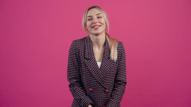 Excited bitch, with a beautiful smile, looks into the room and is happy Beautiful young mature blonde in pink jacket. — 图库视频影像