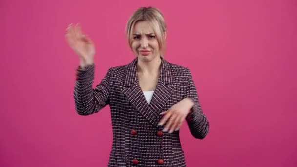 The nice young woman, unwell, gestures, with her hands, annoying Beautiful young mature blonde in pink jacket. — Stock Video