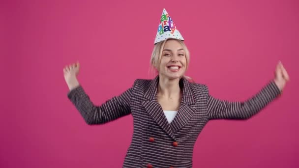 Die glückliche junge Frau, die ihren Geburtstag feiert, trägt einen Kegel auf dem Kopf — Stockvideo