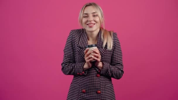 Jovem feliz, segura um copo de papelão de café quente e aquece, sorrindo — Vídeo de Stock