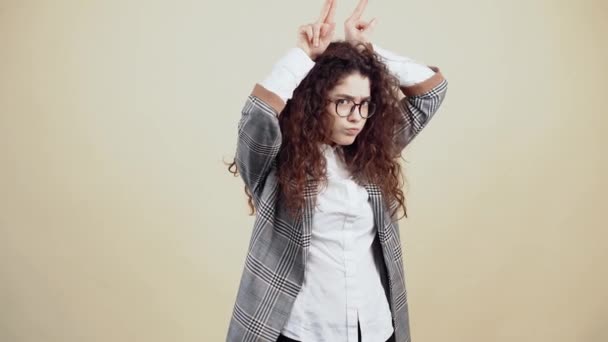 De boze, boze jonge vrouw met haar handen boven haar hoofd geeft stieren hoorns om een gevecht te beginnen. — Stockvideo