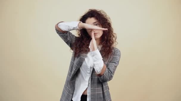 The young businesswoman with her hands points to the stop. Cretaceous in gray jacket and white shirt, with glasses posing isolated on a beige background in the studio. — Stock Video