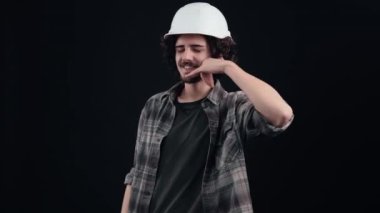 Kıvırcık saçlı zeki bir hippi, seni kamerayı işaret ederek bir telefon konuşmasına davet ediyor. Genç adam kafasına özel bir kask takıyor.,