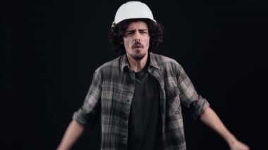 Şok olmuş kıvırcık saçlı hippi ellerini başının üstüne koyup odaya bakıyor, tedirgin ve şaşkın bir şekilde..