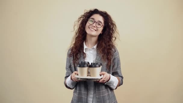 Kreta z szerokim i pięknym uśmiechem trzyma w ręku podpórkę z 4 szklankami, w której znajduje się kawa. — Wideo stockowe