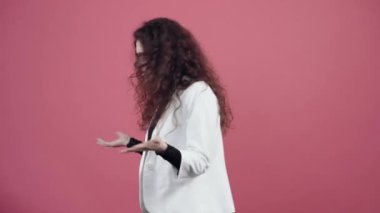 Genç kadının kıvırcık saçlarıyla kafası karışmış, elleriyle jestler yapıyor ve nedenini anlamıyor, bir o yana bir bu yana hareket etmişti. Beyaz ceketli, siyah gömlekli, gözlüklü genç hippi.