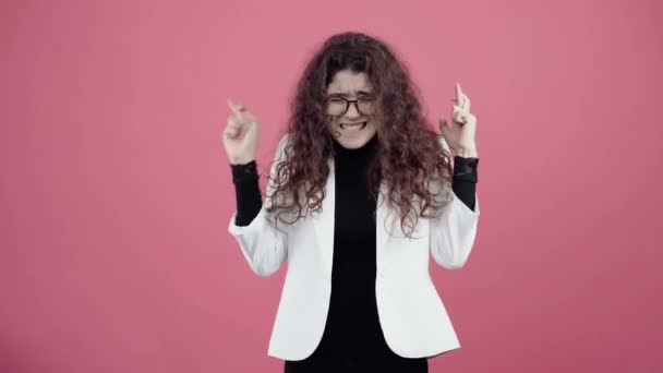 La giovane donna dai capelli ricci, con i capelli incrociati, esprime un desiderio, chiedendo di essere esaudita. Giovane hipster in giacca bianca e camicia nera, — Video Stock