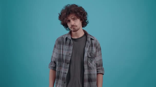 A felelős 20 éves, összecsukott kezű hipszter azt mondja, álljunk meg a stúdióban türkiz háttérrel. A népek életmódjának fogalma — Stock videók