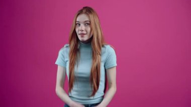 İyimser kızıl saçlı kız kelimeleri sıcak bir şekilde alıyor ve pembe bir arka planda izole edilmiş kalbinde aşkın işaretini elleriyle gösteriyor. İnsanların yaşam tarzı kavramı