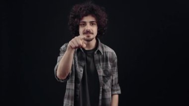 Charismatic young man, amazed, he feels honored to receive a compliment, ashamed he shakes his hands to express his gratitude and brings them to his chest in the shape of a heart to convey love