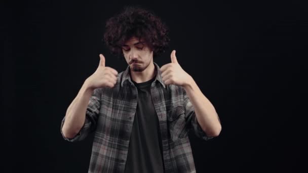 The cheerful young man, with a sincere smile, points to him, then the like sign, demonstrating his good mood. Isolated on black background, Concept of life. Peoples emotions. 4k portrait — Video Stock