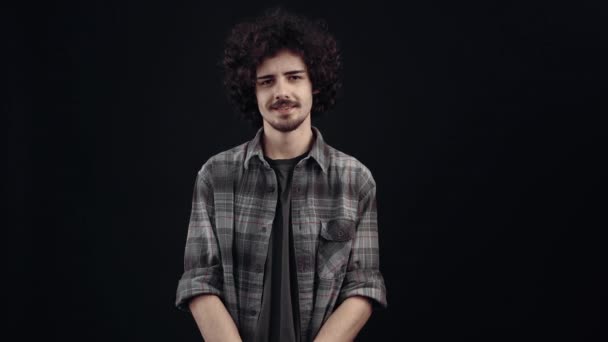 The young thinker, looking ahead, walks his eyes to and fro and then displays a small smile. Isolated on black background, Concept of life. Peoples emotions. 4k portrait — Stockvideo