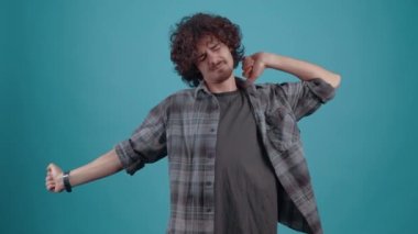 The charismatic, sleepy young man, with his eyes closed, stretches, yawns and puts his hand to his mouth. Isolated on black background, Concept of life. Peoples emotions. 4k portrait