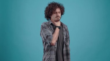 The grieving young man holds his hand to his neck, predicts an acute cold. Isolated on black background, Concept of life. Peoples emotions. 4k portrait