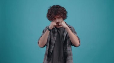 The serious, confident young man raises his arms and positions his fists, being ready for battle. Isolated on black background, Concept of life. Peoples emotions. 4k portrait