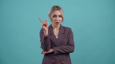The portrait of a beautiful young woman giving a negative index finger cannot be forbidden.Isolated on a turquoise background. The concept of life. Peoples emotions. 4k portrait