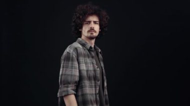 The charismatic young man, in profile, turns frowning, says what and raises his hands terrified in his head. Isolated on black background, Concept of life. Peoples emotions. 4k portrait