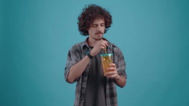 Karizmatik çocuk pipetle dumanın tadını alıyor ve harika tadı karşısında hayrete düşüyor. Turkuaz bir arka planda izole edilmiş. Hayat kavramı. İnsanların duyguları işte. 4k portre