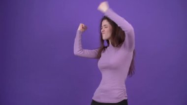 Hadi dans edelim. Kaygısız kız hip hop müziğinin altında karizmatik bir şekilde dans ediyor. Mor bir arka planda, mor bir kazak giymiş esmer kadın. Yaşam tarzı kavramı