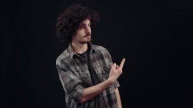 İşte, hadi, bu harika. Genç hippi, arkadaşını onunla harika bir yere gitmesi için taklit ederek teşvik ediyor. Siyah arka planda izole edilmiş, yaşam kavramı. İnsanların duyguları işte. 4k portre