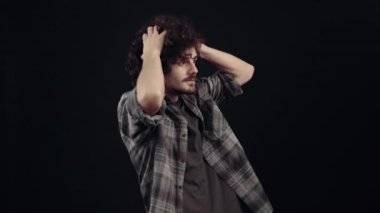 Hayretler içinde kalmış bir çocuğun portresi ellerini başının üstüne koyuyor, işaret parmağıyla sola doğru işaret ediyor ve şöyle görünüyor. Siyah arka planda izole edilmiş, yaşam kavramı. İnsanların duyguları.