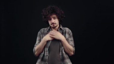 Tebeşir gibi çocuk, Hpster, aldığı övgüden utanıyordu, ellerini göğsüne koydu ve mütevazı bir gülümseme sergiliyordu. Siyah arka planda izole edilmiş, yaşam kavramı. Halklar