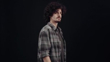 Tebeşir gibi ve yakışıklı çocuk, profil olarak, önde döner, hayretle bağırır wow, öyle görünüyor, sonra profilden geri döner. Siyah arka planda izole edilmiş, yaşam kavramı. İnsanların duyguları işte. 4k