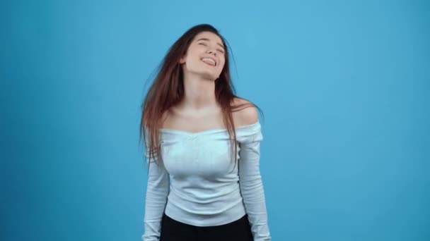 Il viso allegro e carismatico mostra una lingua giocosa e mostra un ampio sorriso. Asiatico con i capelli scuri, vestito con una camicetta blu, isolato su uno sfondo blu scuro nello studio. Lo stile di vita — Video Stock