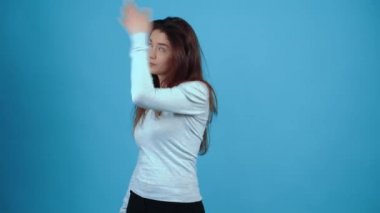 Hayır, kötü şokta olan kız alnına iki kez tokat atıyor. Koyu saçlı, mavi bluz giymiş, stüdyoda koyu mavi bir arka planda izole edilmiş bir Asyalı. Samimi yaşam tarzı konsepti