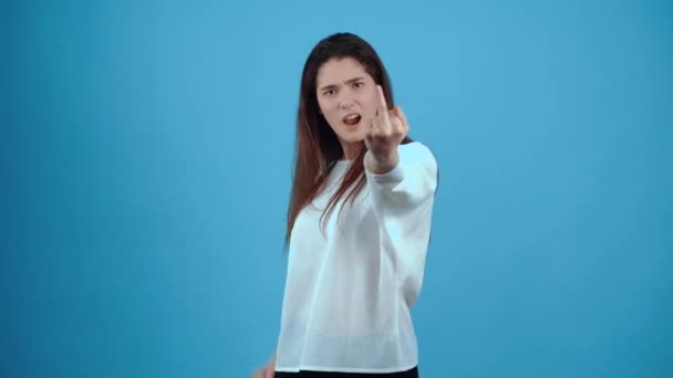 The energetic, annoyed girl looks fuck you with both hands. Asian with dark hair, dressed in a blue blouse, isolated on a dark blue background in the studio. The lifestyle concept of sincere emotions — Stok video