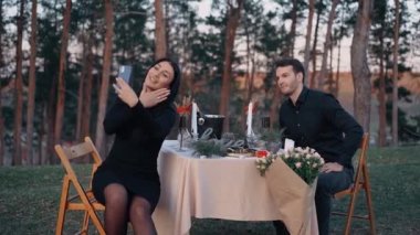 Kendinden geçmiş ve mutlu genç kadın video boyunca konuşuyor ve elini parmağındaki nişan yüzüğünün olduğu yere gösteriyor. Adam mütevazı bir gülümsemeyle ona hayranlıkla bakıyor. Doğada izole edilmiş.