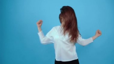 Dans hareketleri yapan karizmatik bir kızın portresi, hip-hop. Koyu saçlı, mavi bluz giymiş, stüdyoda koyu mavi bir arka planda izole edilmiş bir Asyalı. Samimi yaşam tarzı konsepti