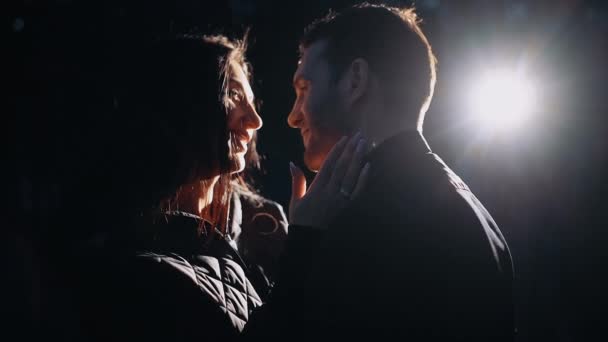 Zbliżenie młodych kochanków stojących twarzą w twarz pod rozproszonym światłem lamp — Wideo stockowe