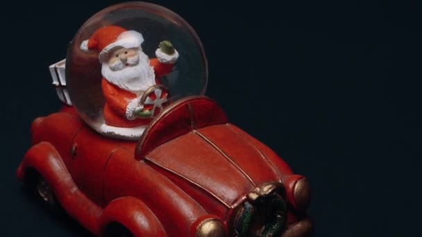 Perfektní rám hračky, která představuje Santa Clause nesoucího dárky v kufru červeného retro auta. Dětské hračky, zimní koncept. Vánoce a Nový rok — Stock video