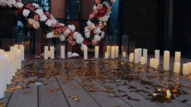 Sevgi sunağı, mumlarla çevrili, çiçeklerden yapılmış kalp, yerde parlak süsler. Aşk kavramı. 4K portresi