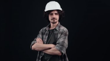 Mühendis miğferindeki yakışıklı çocuk kaşlarından yaygara koparıyor ve sonra elini alnına koyuyor ki ufku daha iyi görebilsin, işiyle daha mutlu olsun. İzole edilmiş