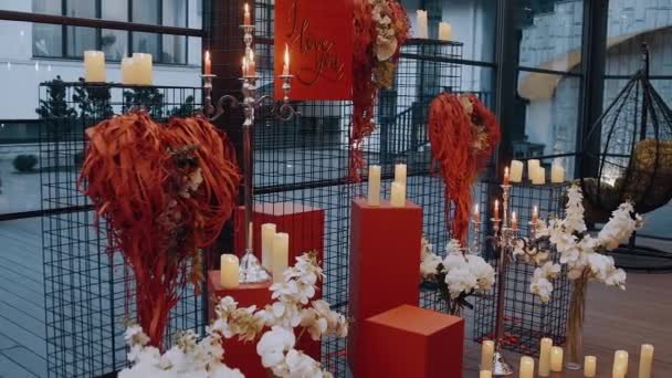 Το τέλειο σκηνικό για να επιδείξετε αληθινή αγάπη, κεριά, λουλούδια και στολίδια σε σχήμα καρδιάς, ένα σημάδι που λέει ότι σας αγαπώ. Κόκκινη ιδέα, το χρώμα της αγάπης. 4k πορτρέτο — Αρχείο Βίντεο