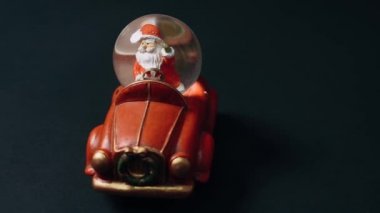 Noel Baba seni selamlıyor. Noel Baba 'nın hediyelerini taşıdığı kırmızı araba şeklinde küçük bir retro oyuncak. Çocuk oyuncakları, kış konsepti. Noel ve Yeni Yıl