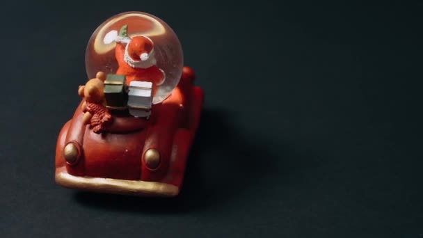 Le dos d'un jouet parfait, rouge rétro, le Père Noël salue, jouet miniature sous la forme d'une voiture qui a des cadeaux dans le coffre. Jouets pour enfants, concept d'hiver. Noël et Nouvel An — Video